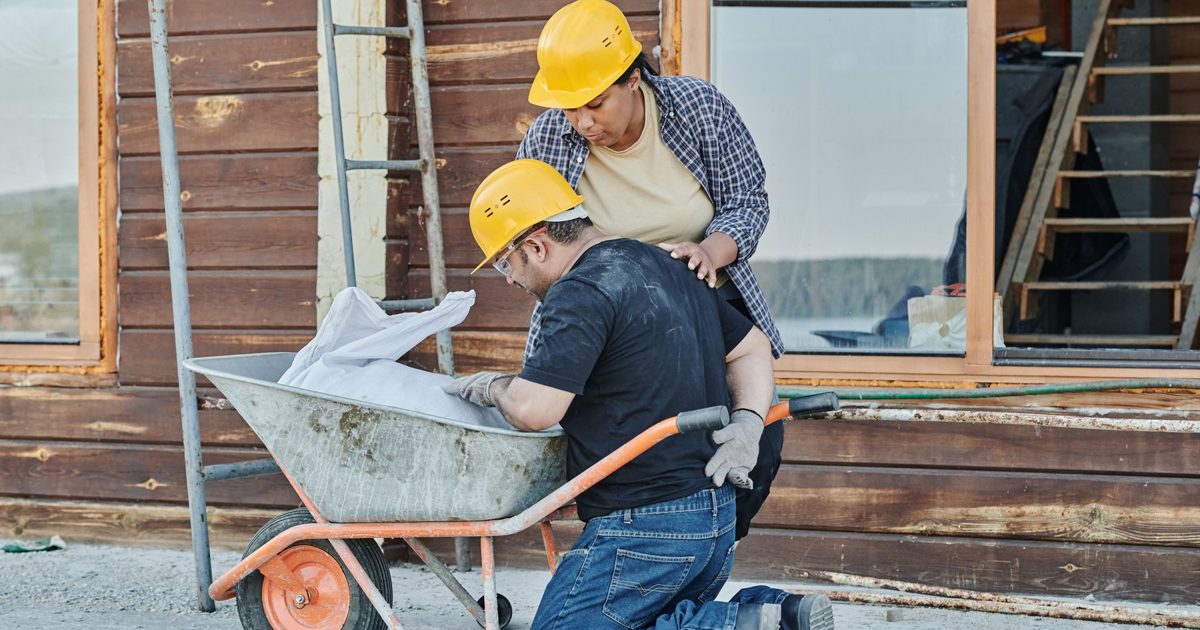 Stock photo of construction workers on a job site, illustrating workplace death benefits for families after a trench collapse